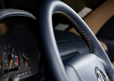 close up of a car steering wheel showing dashboard gauges with speedometer and tachometer in a vehicle interior designed for comfort and style featuring twelve stylish details